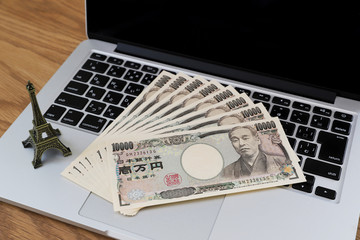 Macのノートパソコンとお金（一万円札） 