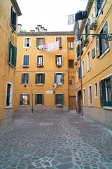 narrow Venetian street surrounded by colourful building