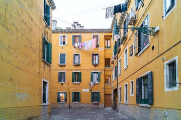 narrow Venetian street surrounded by colourful building