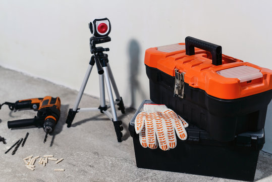 Set of various tools with plastic box kit, drill, gloves, and laser level. Construction and renovation concept with copy space