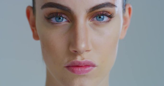 Slow motion close up of young woman with beautiful face and perfect skin just cleaned from impurities ready for day or night cream is looking in camera. 
