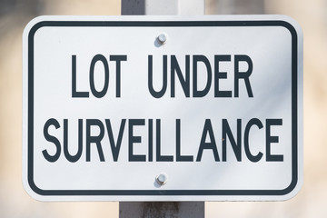 Sign saying 'lot under surveillance' - close up image with great detail