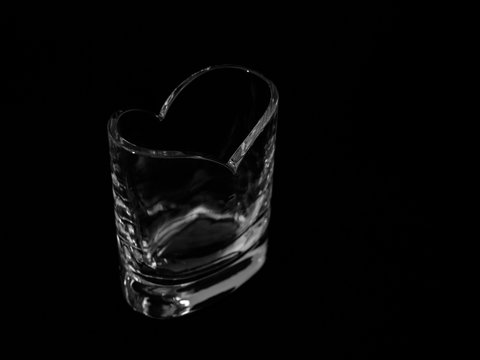 Florero de cristal con forma de coraz&oacute;n en fondo negro