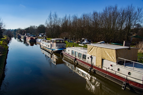 The canal boat and repair yard in Sawbridgeworth with derelict canal boats awaiting repairs on a sunny day in winter.