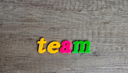 Team  sentence written with  plastic letters on a wooden table .