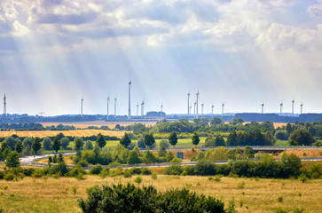 Wind farm in nature with dramatic cloud sky at a highway in Mecklenburg Vorpommern. germany