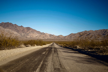 Empty desert road leading to mountains