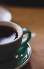 Black coffee in blue cup on wooden background, filter coffee. 