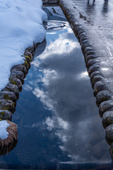 Sky and clouds reflect on the surface of small river. Gifu, Japan