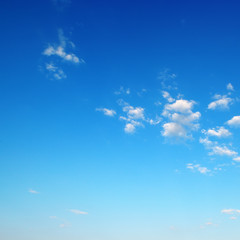 Fototapeta premium Small fluffy clouds on bright blue sky