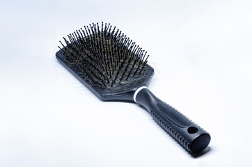 Close up view of a hair brush with hair