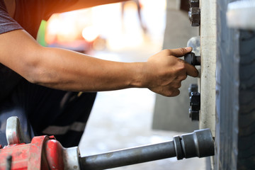 Truck maintenance wheel,Close up of a man unscrew wheel nut of the tire manually, and wheel truck...
