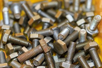 Close up Nuts Bolts and screws in yellow box Background,spot focus.
