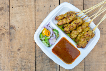 Pork Satay Grilled pork served with peanut sauce or sweet and sour sauce, Thai food on wood table.