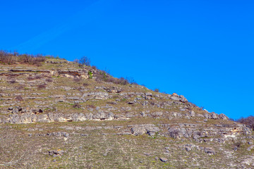Fototapeta na wymiar grey mountain with rocks against blue sky 