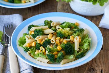 Pasta with corn, broccoli and lettuce on a plate