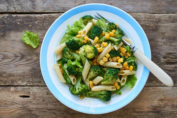 Pasta with corn, broccoli and lettuce on a plate