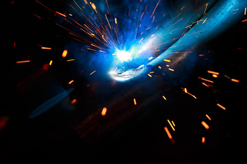 Arc welding. Welding of two metal plates in inert gases. MIG / MAG. A bright flash of light and a...