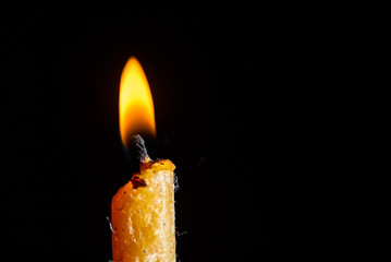 Burning candle close-up, on a dark background.