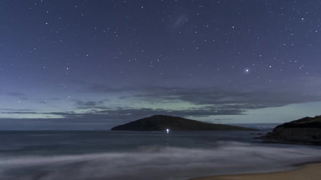 Aurora Australis or Southern Lights in Tasmania with an island and beach in the foreground, moonlit to darkness.