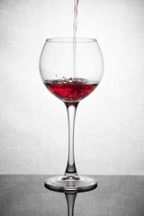  glass goblet on white background with  liquid splashing