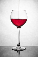  glass goblet on white background with  liquid splashing