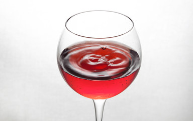  glass goblet on white background with  liquid splashing