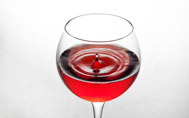  glass goblet on white background with  liquid splashing