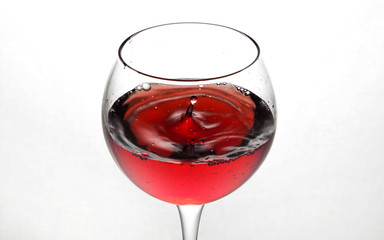  glass goblet on white background with  liquid splashing