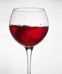  glass goblet on white background with  liquid splashing