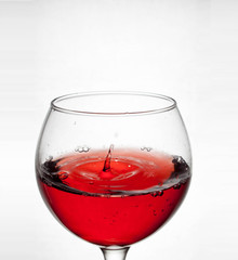  glass goblet on white background with  liquid splashing