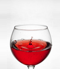  glass goblet on white background with  liquid splashing