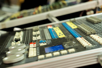 Closeup and crop of knobs with button of sound music mixer control panel on blurry background.