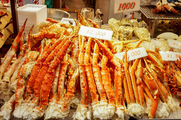 Lots of burned king crab legs ready to serve for customer with labels price at Kuromon market, Osaka, Japan.