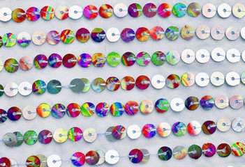 Festive beautiful colorful background for birthday, wedding. Texture of knitted fabric with multicolored iridescent sequins 