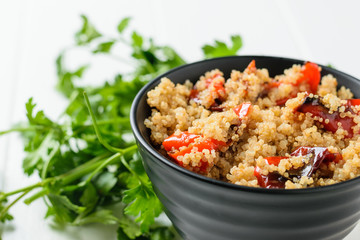 Parsley greens with a bowl of quinoa salad and baked vegetables. Vegetarian dish.