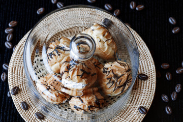 Cake profiteroles with butter cream and chocolate against a dark background. Soft focus.