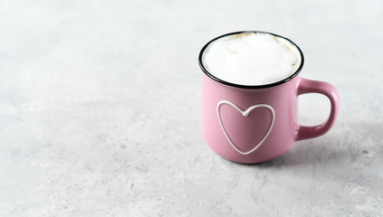 one pink cup cappuccino. cups with  heart, gray background. concept of romance and loneliness, waiting for love.   selective focus and copy space. love card, romantic background