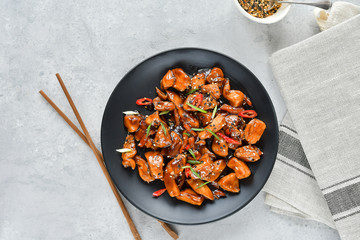 teriyaki chicken's  with  sesame seeds. spicy chicken in sweet and sour sauce with chili pepper. Chinese cuisine, copy space, recipe background, food flat lay, menu of japanese restaurant
