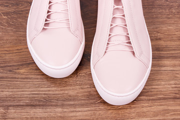 Womanly pink leather shoes on rustic board
