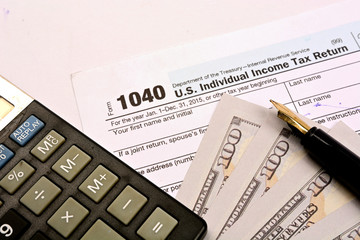 Calculating US tax with 1040 tax form on white background