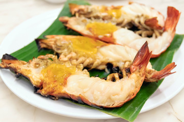 Charcoal grilled giant river prawn usually serve with spicy seafood sauce on green banana leaf in restaurant; Thailand's popular dishes. 