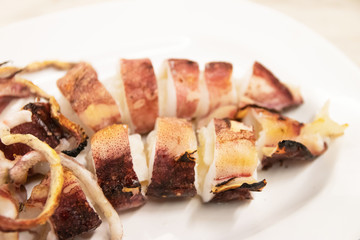 Grilled squid on white plate usually serve with spicy seafood sauce.