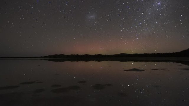 Natures Fireworks - beams of the Aurora Australis or Southern Lights exploding into the sky, all reflected in still water in the foreground. 