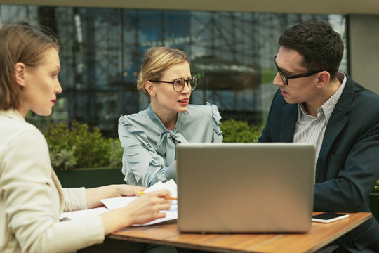 Wondering business woman asking his colleagues about incorrect document