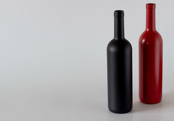 Two bottles of wine of black and red on a white background.