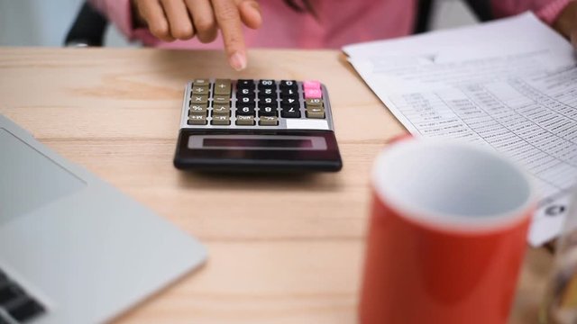 Home finances, investment, economy, saving money or insurance concept. Hands closeup. Close up of female accountant or banker making calculations. 