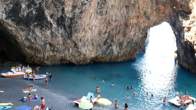 San Nicola Arcella, Cosenza, Calabria, Italy - September 6 2018: bathers in Arcomagno (Arco magno) at sunset, beautiful beach and natural arch on Mediterranean sea (Tyrrhenian)