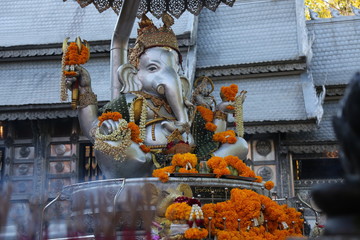 Silver Ganesha sculpture with orange flowers