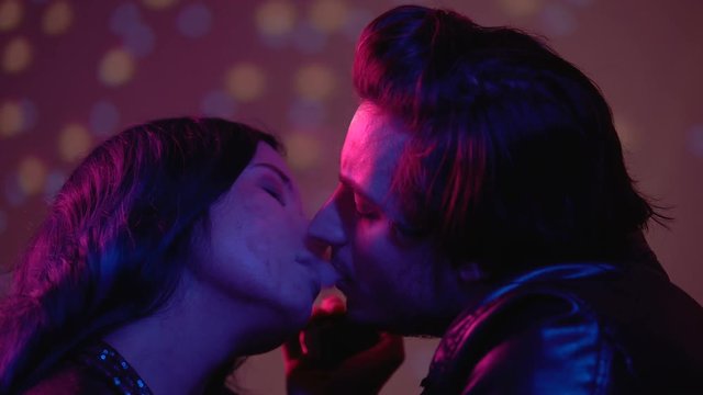 Man exhaling e-cigarette smoke in womans mouth, seducing for one night sex